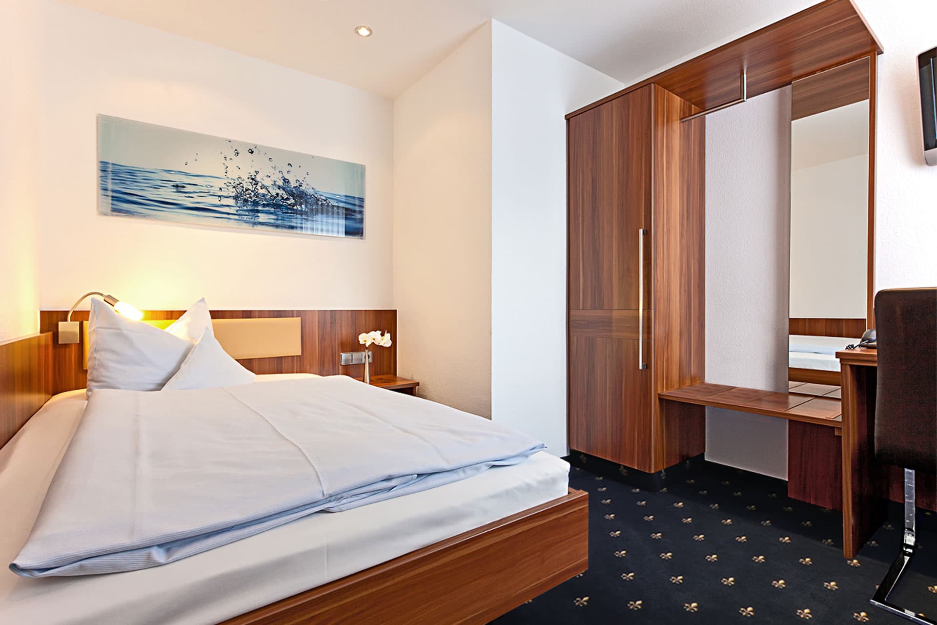 Einzelzimmer mit Bett und Schreibtisch